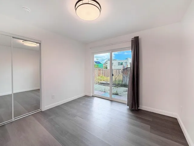 an empty room with wooden floor and a window