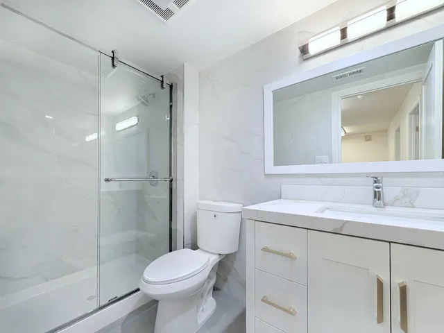 a kitchen with stainless steel appliances white cabinets and wooden floors
