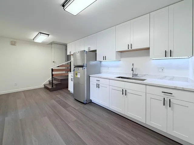 a view of a hallway with wooden floor and staircase