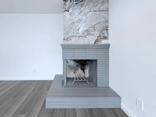 a view of a livingroom with wooden floor and a fireplace