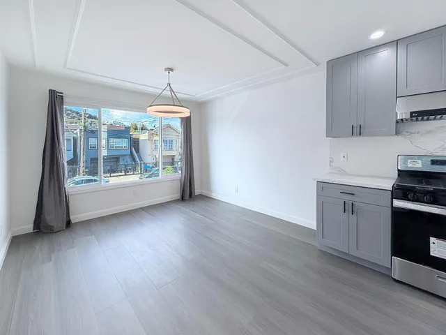 a kitchen with wooden floors and white walls