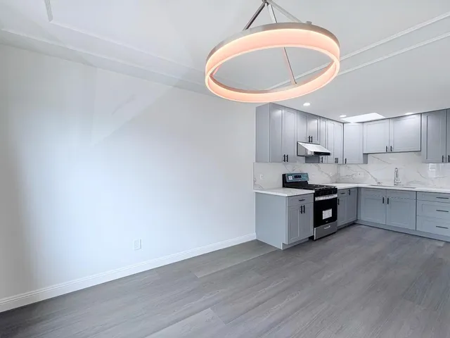 a view of a kitchen with a sink and wooden floor