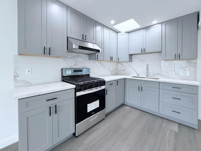 a kitchen with white cabinets stainless steel appliances and sink