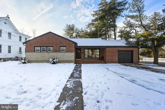 a front view of a house with a yard covered in snow