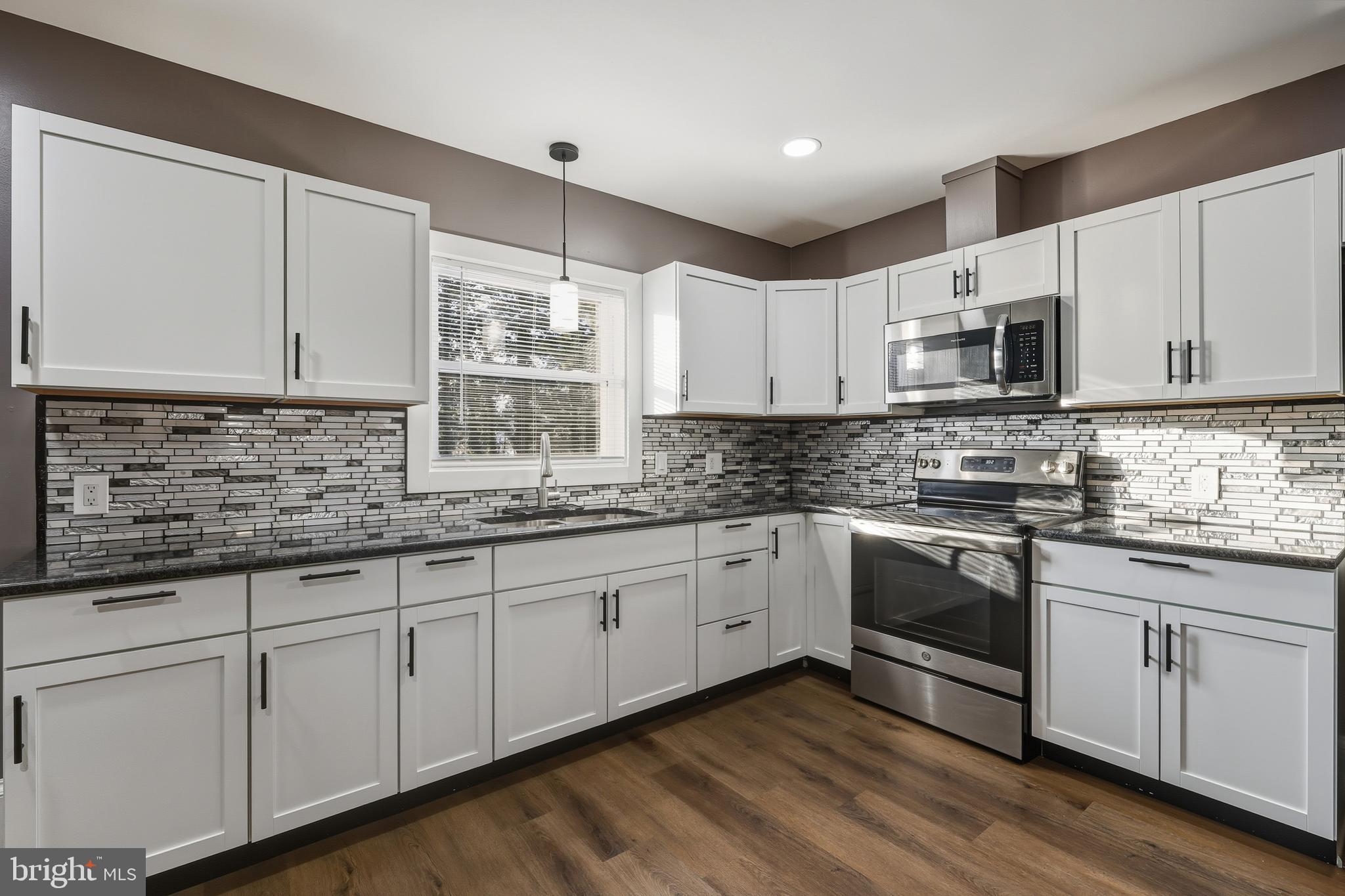 114 Magnolia Avenue Bridgeton, NJ 08302 - Photo 8 of 30 a kitchen with granite countertop white cabinets sink and stainless steel appliances