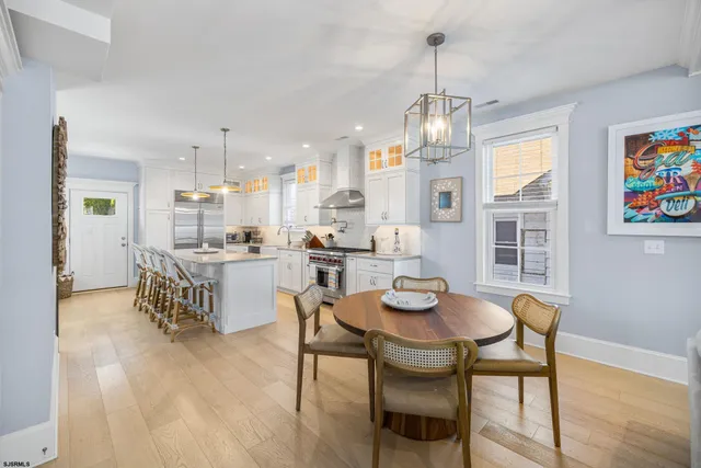 a dining room with furniture a chandelier and wooden floor
