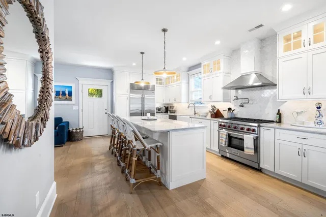 a kitchen with stainless steel appliances granite countertop a stove a kitchen island and chairs