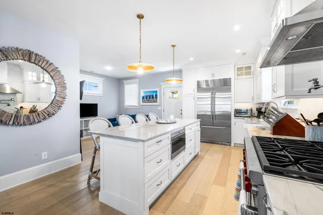 a kitchen with stainless steel appliances granite countertop a table chairs sink and window