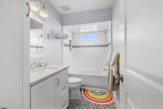 a bathroom with a granite countertop sink a toilet and shower