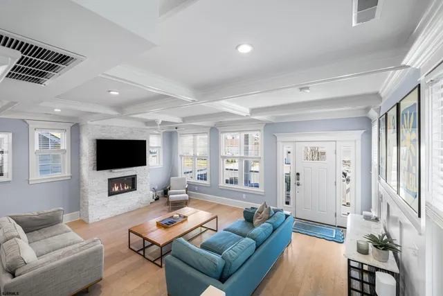 a living room with furniture a flat screen tv and a fireplace