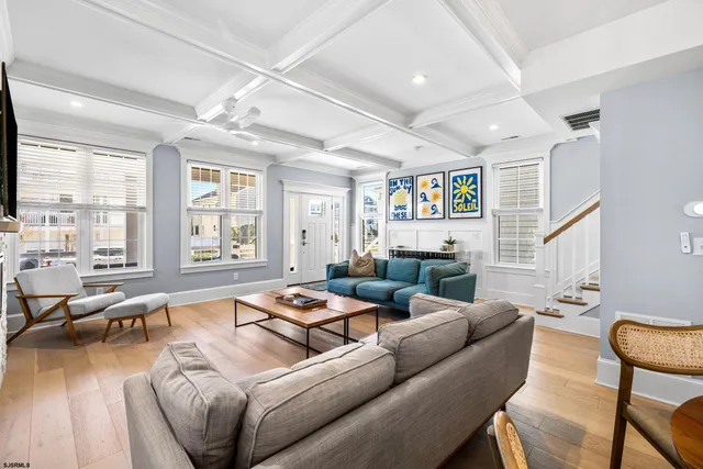 a living room with furniture wooden floor and a large window