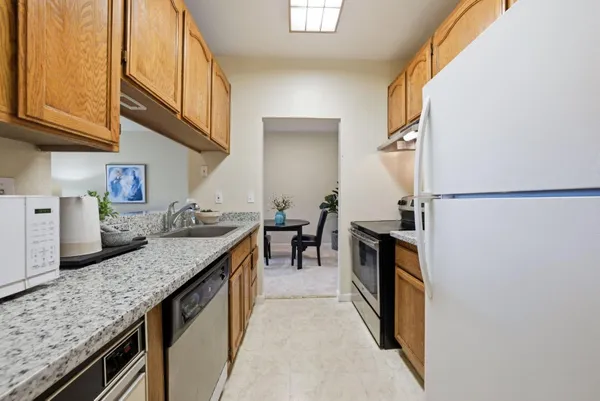 a kitchen with granite countertop a sink a counter top space and stainless steel appliances