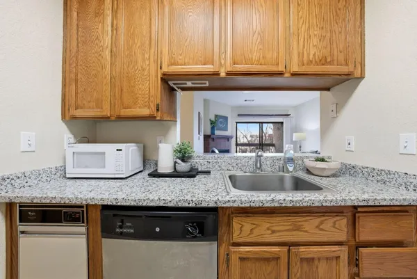 a kitchen with granite countertop a sink a stove and cabinets