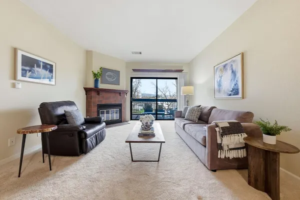 a living room with furniture a fireplace and a large window