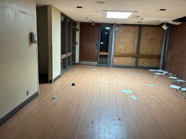 an empty room with wooden floor and closet area