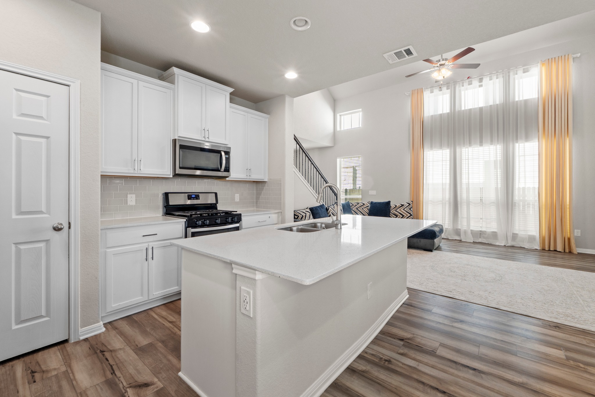 159 MacArthur Drive Leander, TX 78641 - Photo 11 of 31 a large white kitchen with stainless steel appliances a large counter top a stove a chimney a sink and a refrigerator