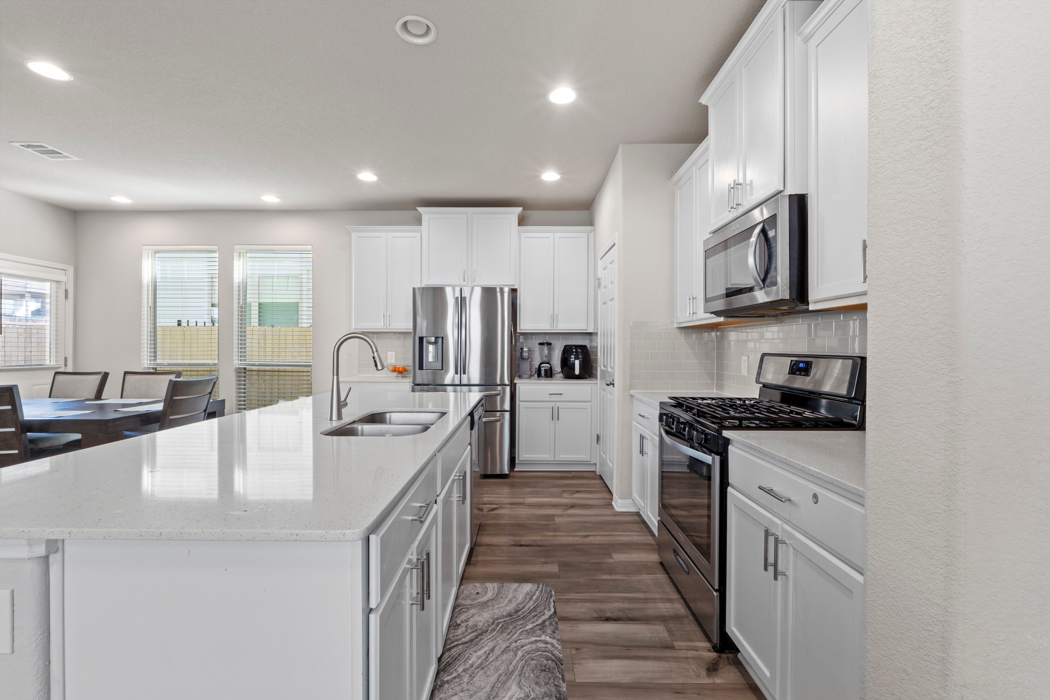 159 MacArthur Drive Leander, TX 78641 - Photo 9 of 31 a large kitchen with stainless steel appliances granite countertop a lot of counter space and wooden floors