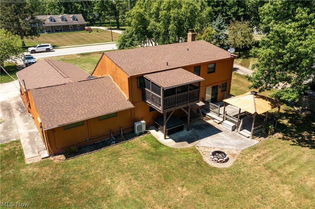 2565 Abbe Road North Sheffield Lake, OH 44054 - Photo 3 of 32 Rear exterior featuring a screened-in porch, ground-level patio, and a built-in fire pit