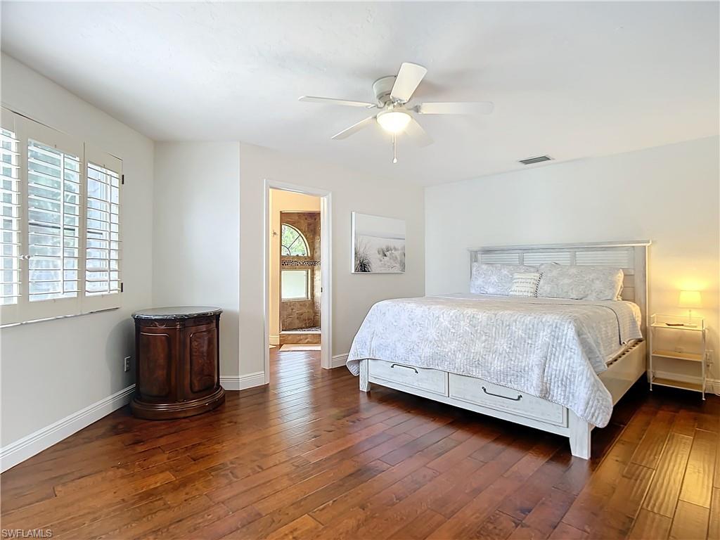 2860 Citrus Lake Drive, Unit R202 Naples, FL 34109 - Photo 34 of 50 a bedroom with a large bed and wooden floor