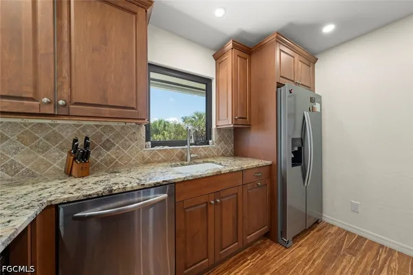 a kitchen with stainless steel appliances granite countertop a sink stove and refrigerator
