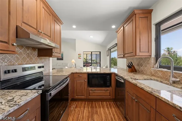 a kitchen with a sink stove top oven and cabinets