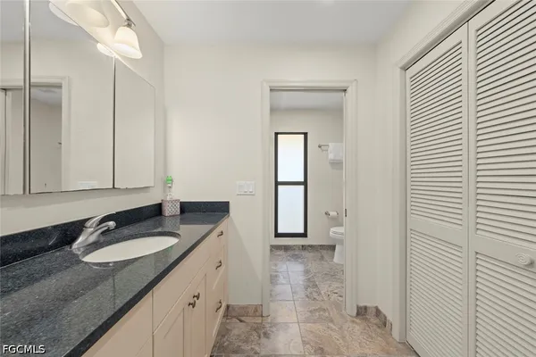 a bathroom with a granite countertop sink and a mirror