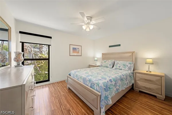 a bedroom with a large bed a chandelier and windows