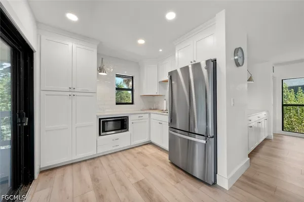 a kitchen with a refrigerator a stove top oven and wooden floor