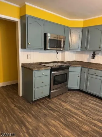 a kitchen with stainless steel appliances granite countertop a stove a sink and a microwave