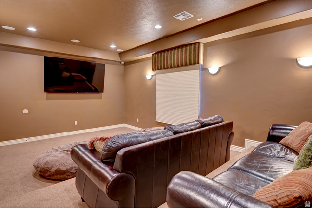 1177 Northfield Road, Unit 26 Cedar City, UT 84721 - Photo 40 of 45 Spacious entertainment room featuring recessed ceiling lighting, wall-mounted sconces, a large wall-mounted screen, and neutral-toned carpeting