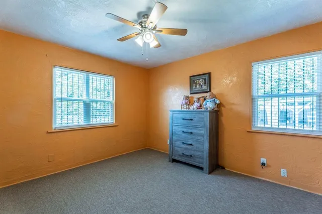 a view of a livingroom with an empty space & a ceiling fan
