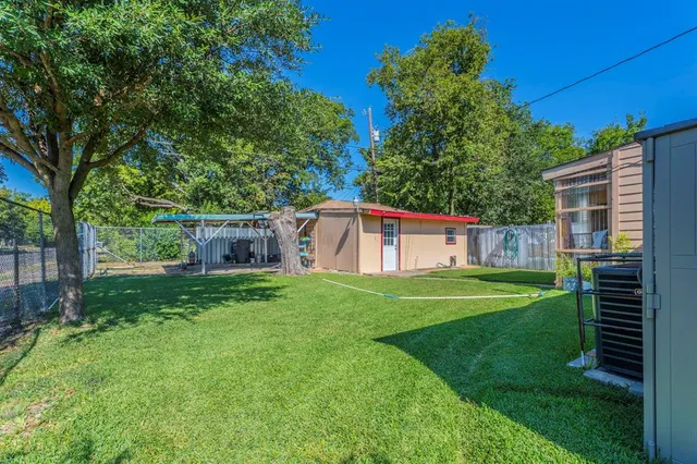a view of a backyard with table and chairs and a large tree
