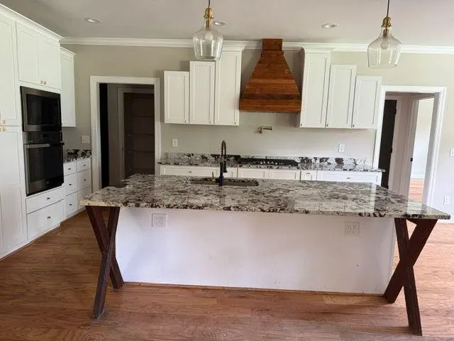 a kitchen with stainless steel appliances granite countertop a sink a stove a refrigerator and island