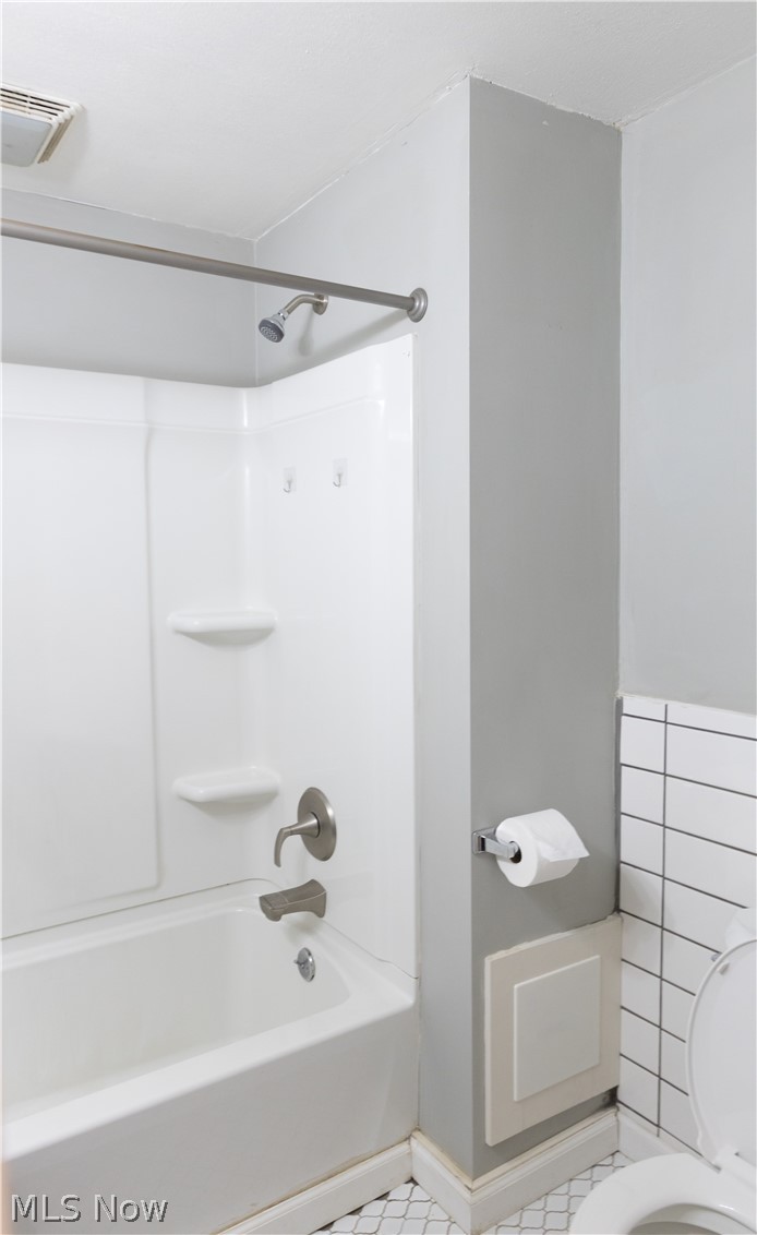 180 South Ridge Road West Geneva, OH 44041 - Photo 29 of 40 Bathroom featuring washtub / shower combination, tile patterned floors, and toilet
