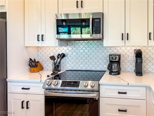 a kitchen with stainless steel appliances kitchen island granite countertop a refrigerator a stove a sink dishwasher and a dining table with wooden floor