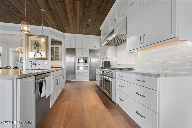 a large kitchen with stainless steel appliances a stove a sink dishwasher and a refrigerator
