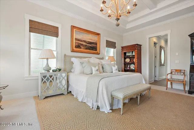 a bedroom with a large bed and a chandelier