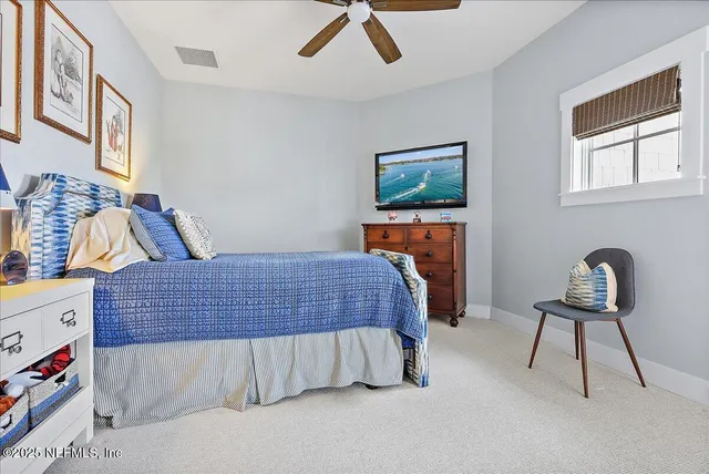a bedroom with a bed next to a window with a bookshelf
