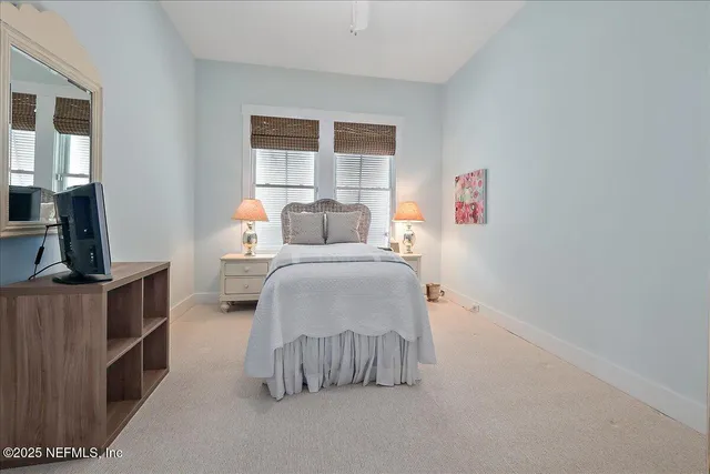 a bedroom with a bed and a flat tv screen on dresser