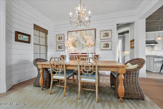 a dining room with furniture a chandelier and wooden floor