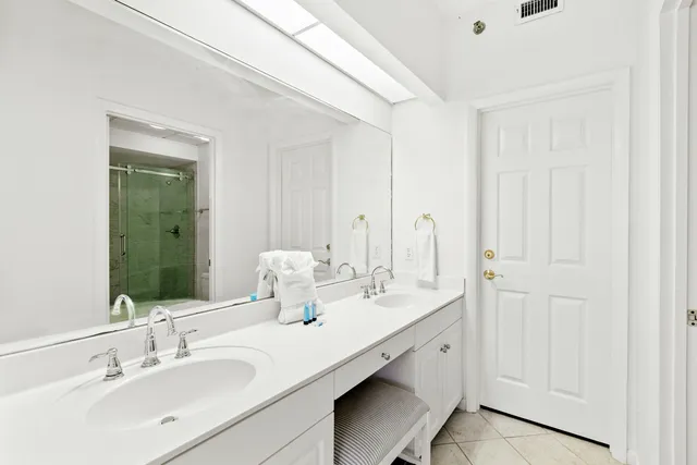 a bathroom with double vanity sinks and a mirror