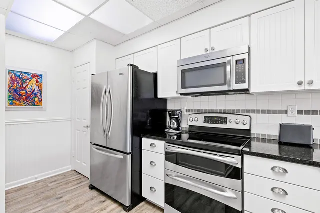a kitchen with granite countertop a refrigerator stove and microwave