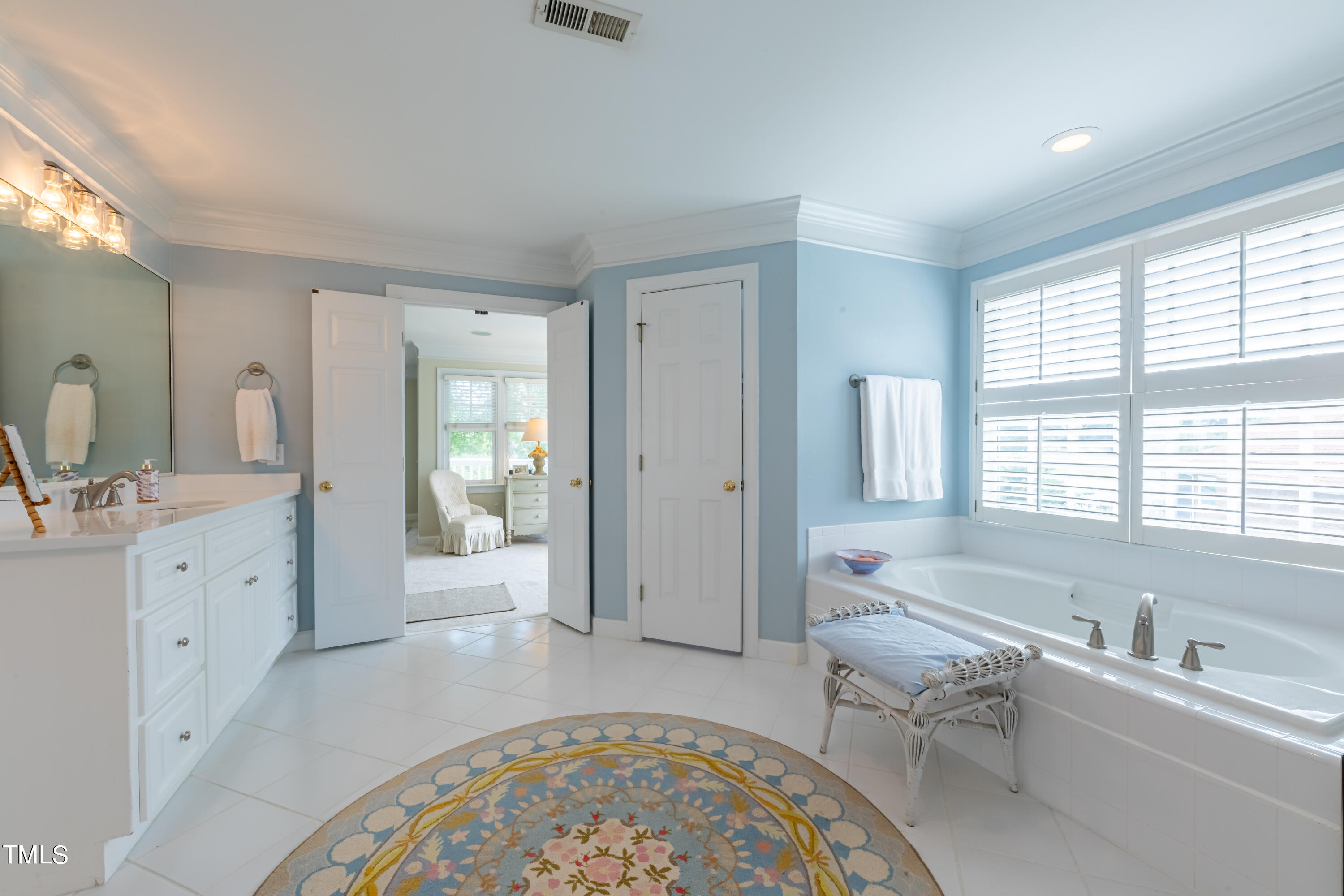 103 Declair Court Cary, NC 27513 - Photo 33 of 47 a spacious bathroom with double vanity a large mirror a bathtub and a shower