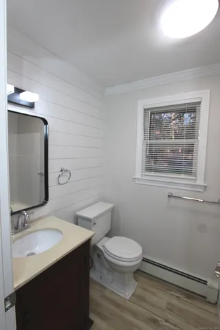 a bathroom with a toilet a sink and mirror
