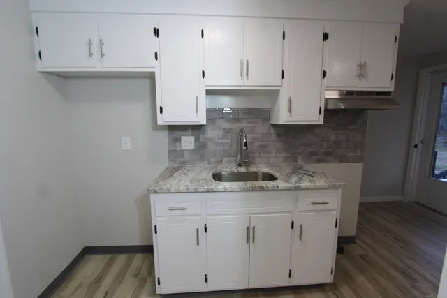 a view of cabinets a wooden floor and a sink