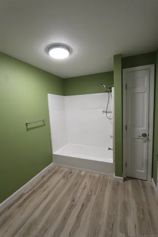 an empty room with wooden floor and entrance