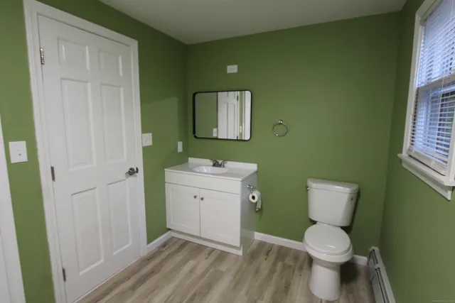 a bathroom with a toilet sink and mirror