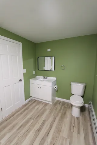a bathroom with a toilet sink and mirror