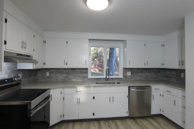 a kitchen with cabinets appliances a sink and a stove