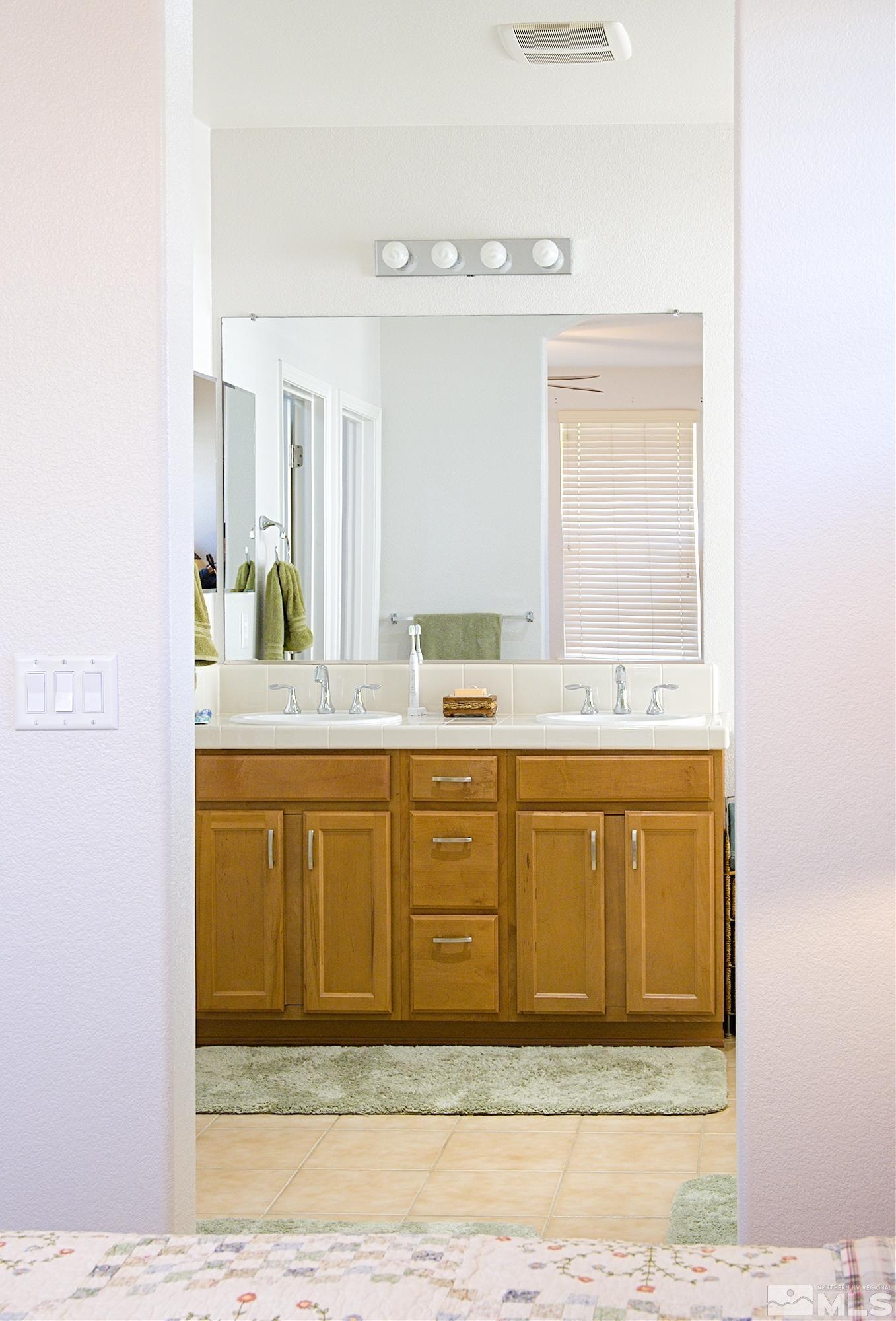 1895 Wind Ranch Road, Unit C Reno, NV 89521 - Photo 10 of 18 a bathroom with a granite countertop sink mirror and vanity